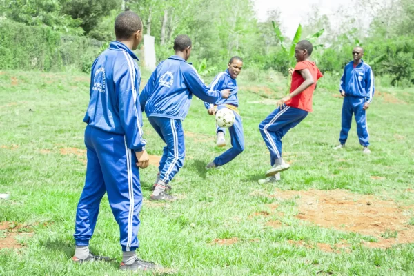 PCEA Enoomatasiani Booth Boys High School - students playing football at the field