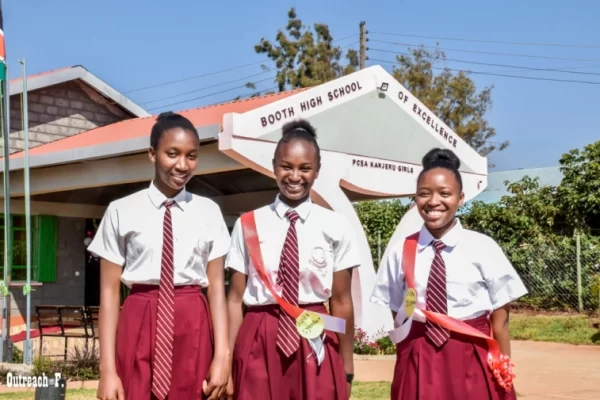 PCEA Kanjeru Booth Girls High School - students standing outside the administration block all smiles